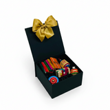 Estuche rígido negro con logo corporativo en dorado conteniendo kit antiestrés de juguetes mexicanos — mini trompo, pirinola y mini jenga para escritorio ejecutivo - Ambiente Mexicano